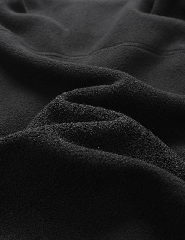 Black fleece vest fabric close-up showing the soft textured surface and folds