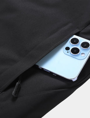 Black heated golf vest with a smartphone tucked into the side pocket