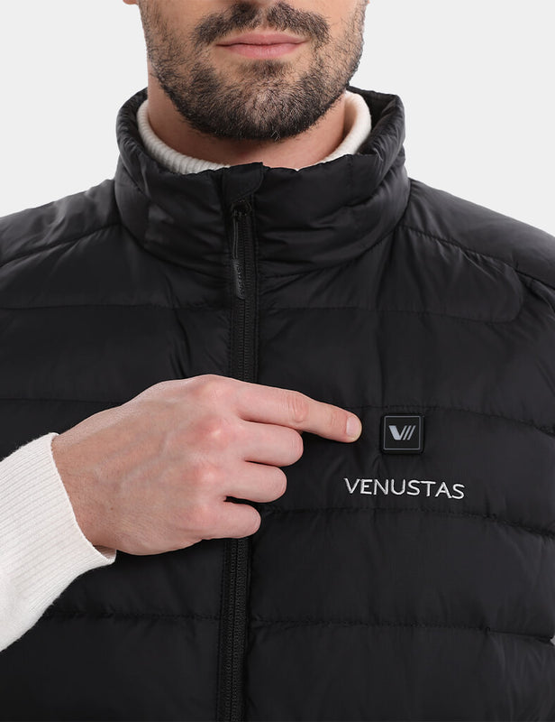 Close-up of the black heated vest showing the chest logo, front zipper, and stand collar
