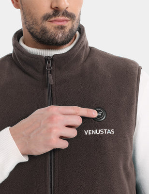 Model wearing a brown heated fleece vest and pressing the chest power button