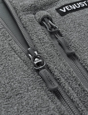 Close-up of gray fleece vest front zipper pulls and chest pocket