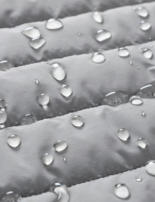 Water droplets beading on the gray quilted heated vest fabric