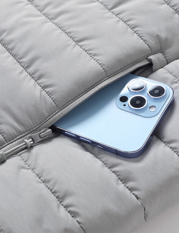Gray heated vest zippered pocket holding a smartphone