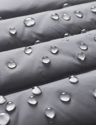 Close-up of gray vest fabric with water droplets on the quilted surface