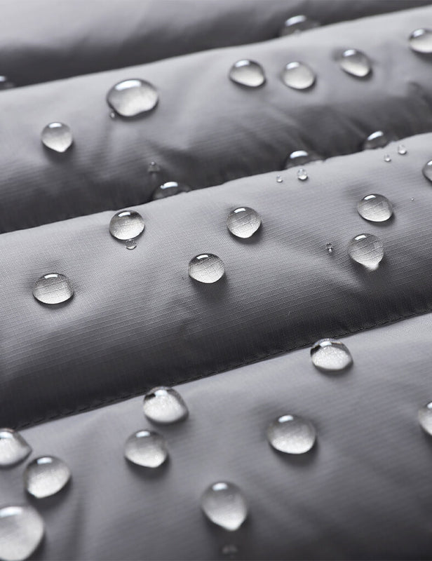 Close-up of gray vest fabric with water droplets on the quilted surface