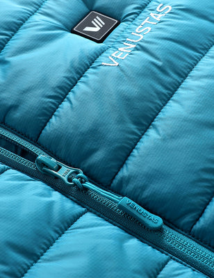 Close-up of teal quilted vest fabric with zipper pull and chest logo